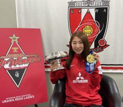 写真:カップとメダルを持つ塩越選手