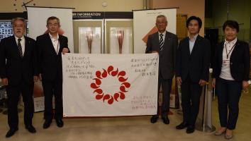 写真：トーチの前に並ぶ川合市長と市議会議員