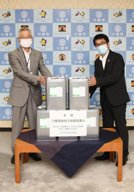 写真：アルコール消毒液（15リットル入り）5缶寄贈の様子