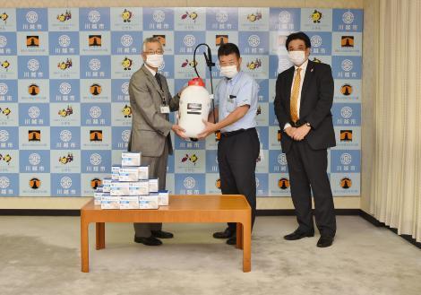 写真：マスクと動力噴霧器の寄贈の様子