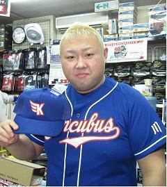 写真：ユニフォームを着てキャップを手に持つ脇さん