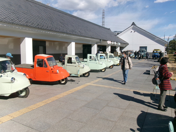 博物館エントランスに昭和の自動車が複数台展示されている様子の写真