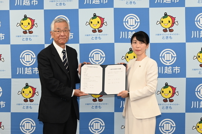 写真：事務引継書を掲げる川合前市長と森田市長
