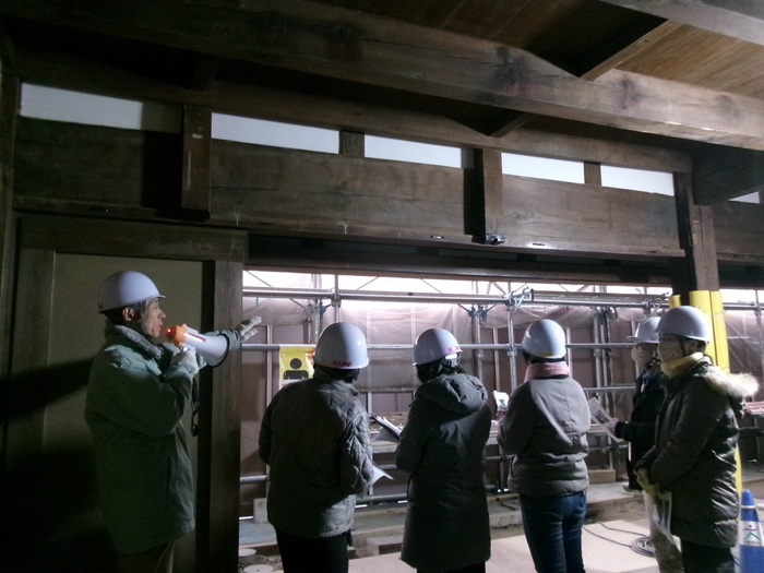 耐震補強壁について説明する職員と説明を聞く参加者の写真