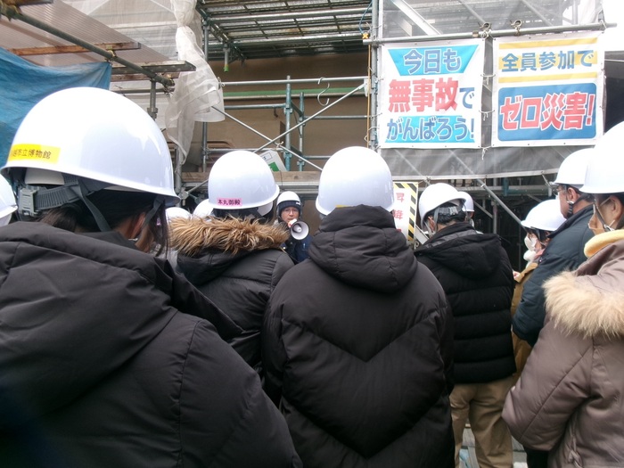 蔵造り資料館の前で職員が説明しているのを参加者が聞いている様子の写真