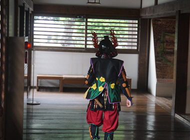 （写真2）以前の体験教室で、鎧を着て本丸御殿の廊下を歩いている様子の写真