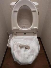 便座を上げて便器にビニール袋を被せた写真