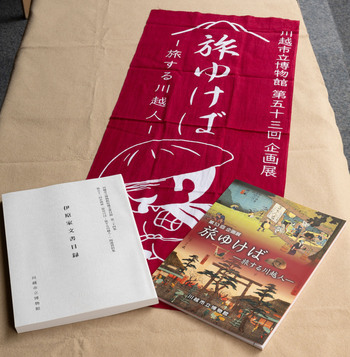 第53回企画展「旅ゆけばー旅する川越人ー」図録(画面向かって右)、関連資料集(画面向かって左)、てぬぐい(画面中央)