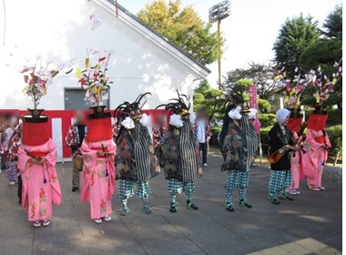 3頭の獅子舞、山の神、4人の花笠が博物館エントランスに並び実演している様子の写真